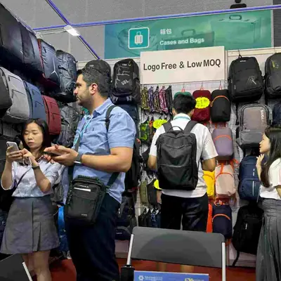 Visitors examining backpacks on display at the SANDA exhibition stand