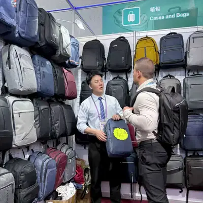 Visitor looking at backpacks arranged along the SANDA booth wall